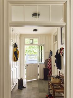 an entry way with white walls and tile flooring