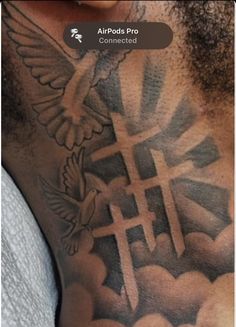 a man with a cross and dove tattoo on his chest