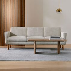 a living room with a couch, coffee table and wooden slats on the wall