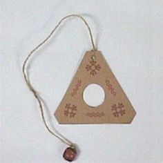 a wooden ornament hanging from a string on a white background with a bead