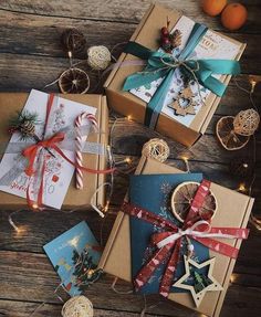 presents wrapped in brown paper and tied with ribbon on top of a wooden table next to oranges