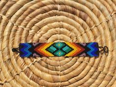 a colorful beaded bracelet sitting on top of a wicker basket with an oval design