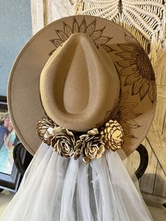 a hat on top of a chair with tulle around the brimmed hat