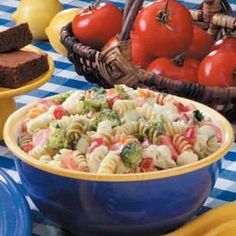 a table topped with plates and bowls filled with pasta salad next to other food items