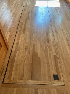 an empty kitchen with wooden floors and cabinets