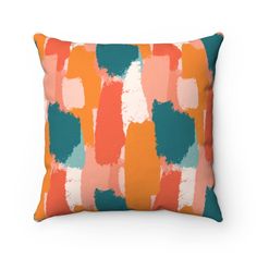 an orange and blue pillow with colorful paint strokes on it