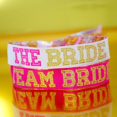 the bride team bracelets are stacked on top of each other in pink and gold