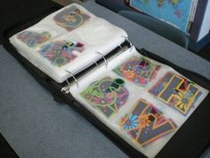 an open binder with stickers on it sitting on a table next to a book