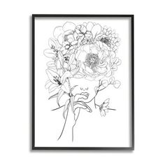 a black and white drawing of flowers in a frame on the wall next to a plant