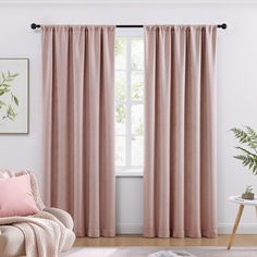 a living room with pink curtains and a chair