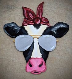 a cow with a red bow on it's head is painted in black, white and pink