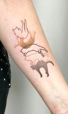 a person with a tattoo on their arm that has two cats and a bird in it