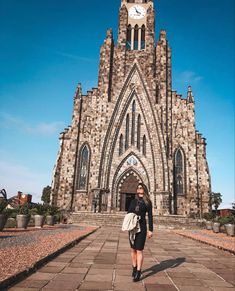 a woman is standing in front of a church