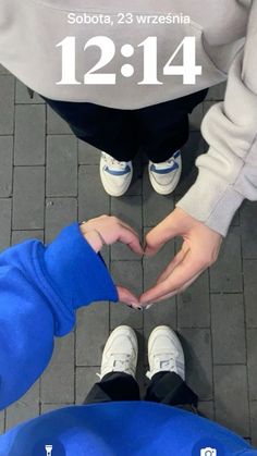 two people making a heart shape with their hands on the ground in front of them