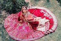 a woman sitting on top of a pink blanket