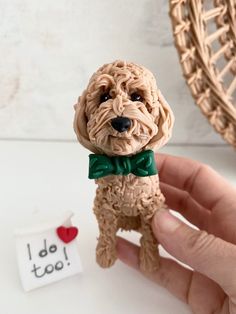 a small toy dog with a green bow tie