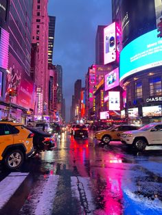 a city street filled with lots of traffic and tall buildings covered in neon colored lights