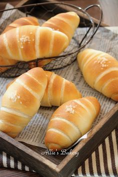 four loaves of bread sitting on top of a wooden tray