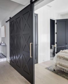 an instagramted photo of a bedroom with black doors