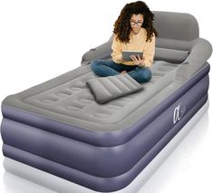 a woman sitting on an inflatable bed using a tablet