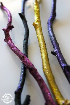 three different colored sticks sitting next to each other on a white counter top with gold and purple flecks