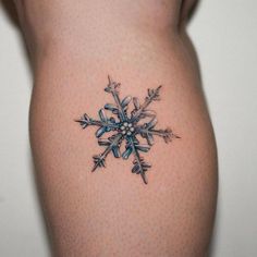 a snowflake tattoo on the back of a woman's thigh is shown