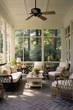 the sun shines through the large windows into an enclosed porch with wicker furniture