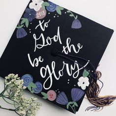 a black graduation cap with flowers on it and the words to god be glory written in white