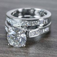 a couple of wedding rings sitting on top of a wooden table next to each other