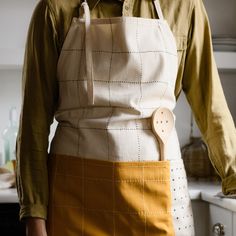 a person wearing an apron holding a wooden spoon