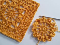 two crocheted squares are next to each other on a white surface, one is yellow and the other is orange