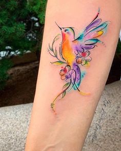 a colorful bird tattoo on the leg