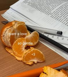 an orange sliced in half on top of a table next to a book and scissors