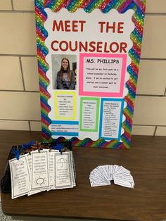 a table topped with lots of cards and papers next to a sign that says meet the counselor