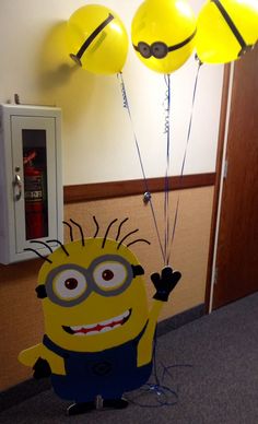 a minion holding balloons in the air