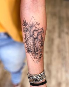 a woman's arm with a heart tattoo on it and flowers in the middle