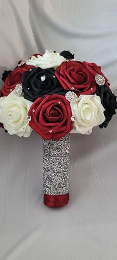 a bridal bouquet with red, white and black flowers