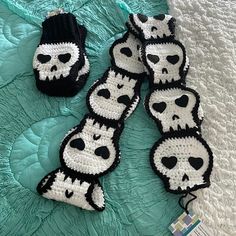 crocheted panda bear mitts and gloves laying on a bed with blue sheets