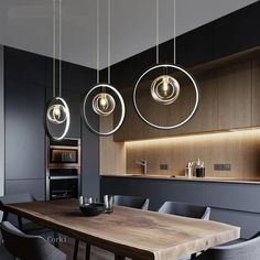 a dining room table with chairs and lights hanging from it's ceiling above it