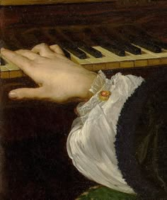 a close up of a person's hand playing the piano