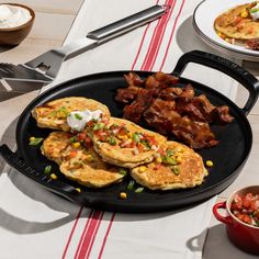 pancakes with bacon, corn and sour cream are on a plate next to other breakfast foods