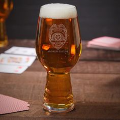 a beer glass sitting on top of a wooden table