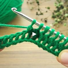 someone is crocheting the stitchs together with green yarn