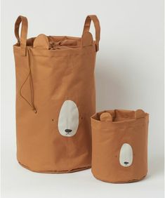 two brown bags with faces on them are sitting next to each other and one has a bag in the shape of a bear's head