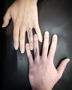 two people with matching rings on their fingers, one holding the other's hand