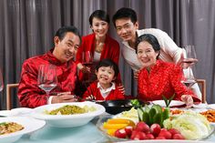 a family posing for a photo at a table with food and wine in front of them