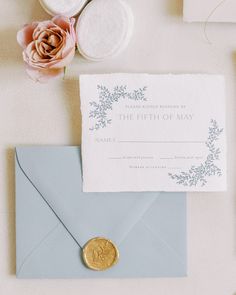 an envelope with a wax seal and some flowers