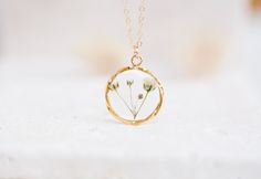 a necklace with flowers in it on a white surface