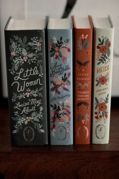 three books sitting on top of a wooden table