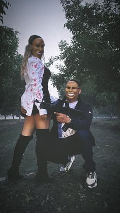 a man and woman posing for a photo in front of trees with a mask on